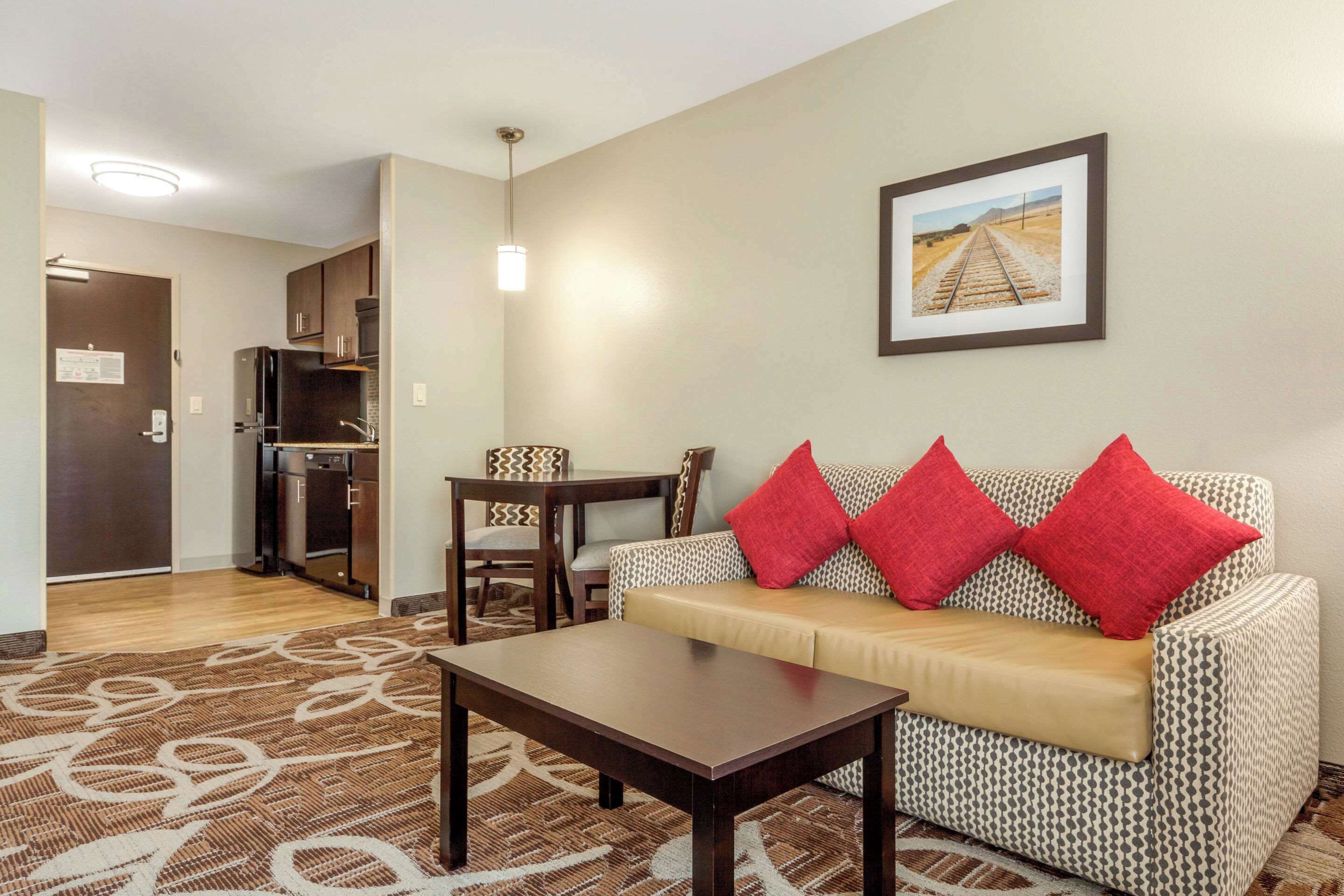 A living room with a sofa, a coffee table, and a dining area with a table and chairs.