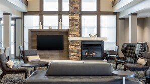 Ein stilvoller Lounge-Bereich mit Kamin, Ledersofas und einem Flachbildfernseher.