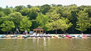 Un entorno junto al lago con un pabellón y una hilera de canoas.