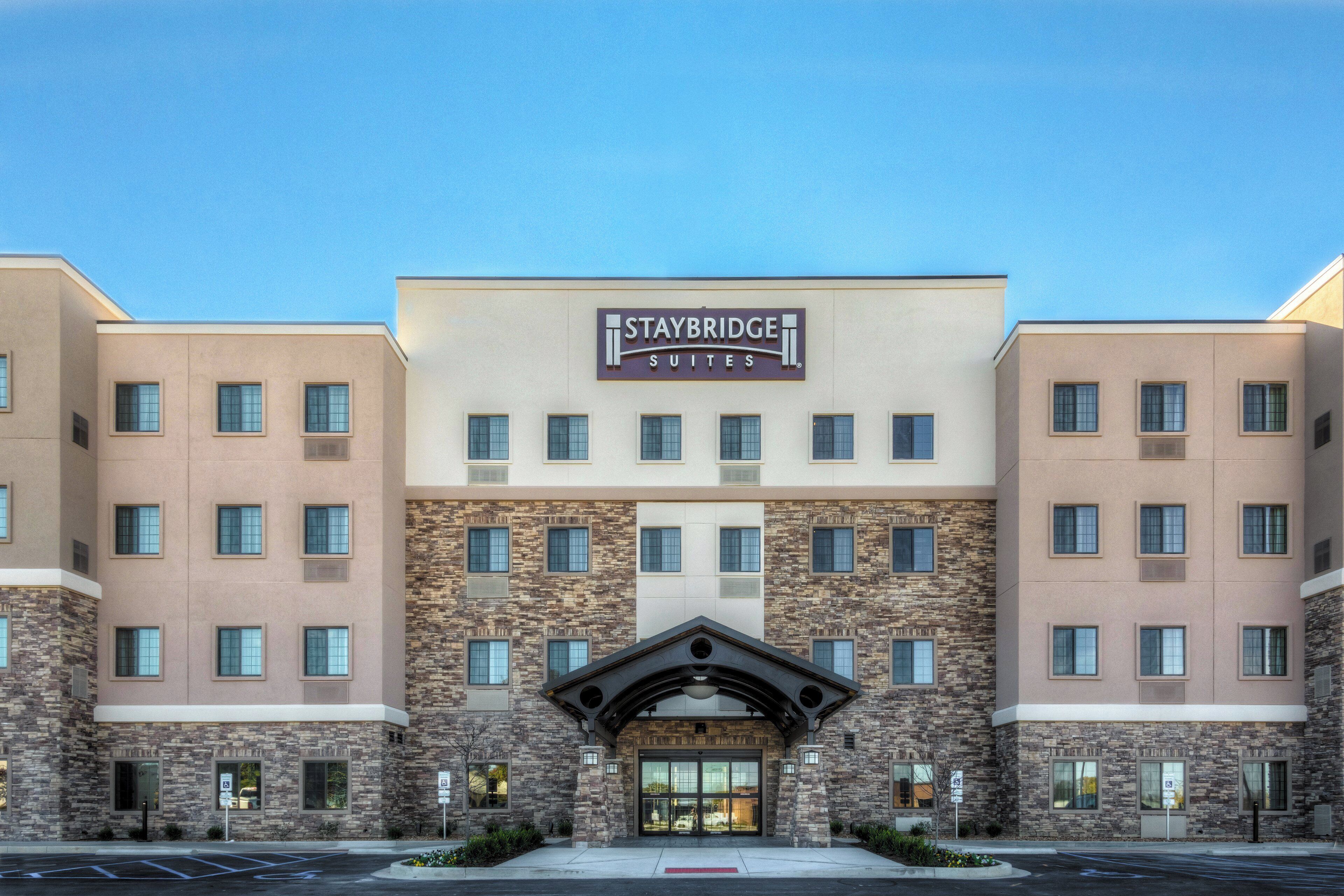 A Staybridge Suites hotel with a modern facade, multiple windows, and a prominent entrance.