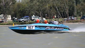 A speedboat with the number 167 and the name "Hellrazor" on its side, moving through water with a wake behind it.