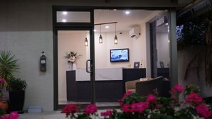 A reception area with a reception desk, a television screen, and a potted plant. - Loddon River Motel (Kerang)