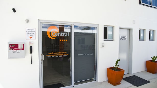 A hotel entrance with a reception desk, a guest laundry sign, and a phone for after-hours key safe access.