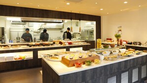 Ein Buffetbereich mit verschiedenen Speisen und einer Küche im Hintergrund.