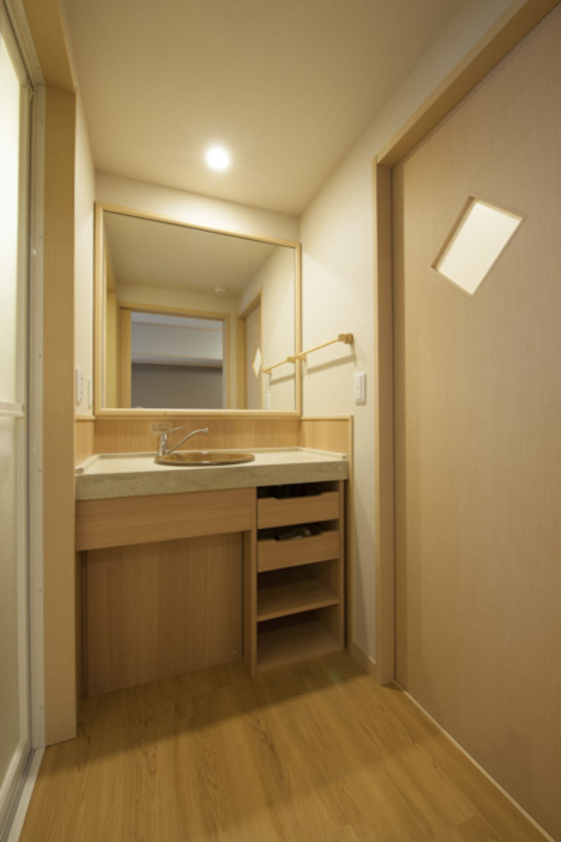 A bathroom with a wooden vanity, a sink, and a mirror.