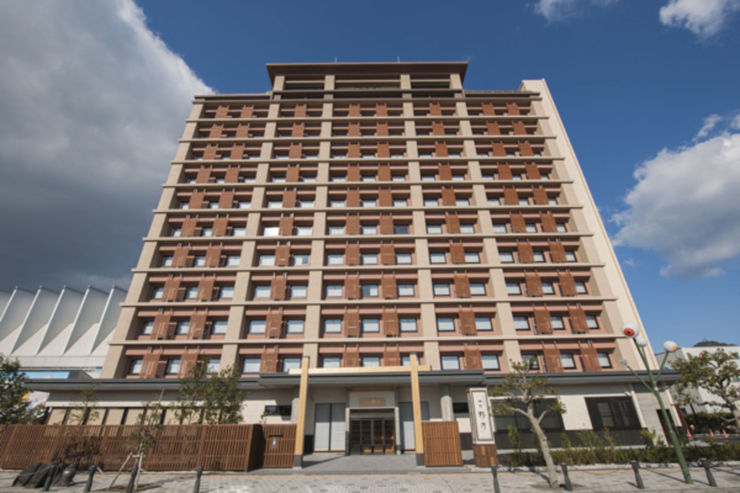 Ein modernes, mehrgeschossiges Hotel mit symmetrischer Fassade, großen Fenstern und einem zentralen Eingang.