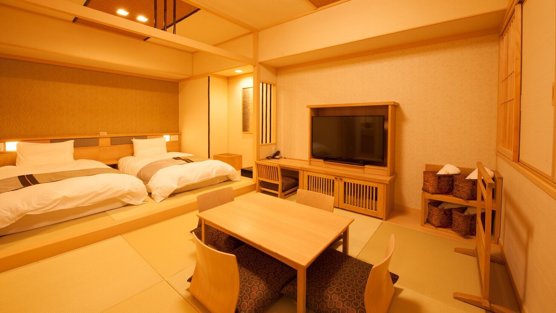 A hotel room with a bed, a TV, a desk, and a chair.