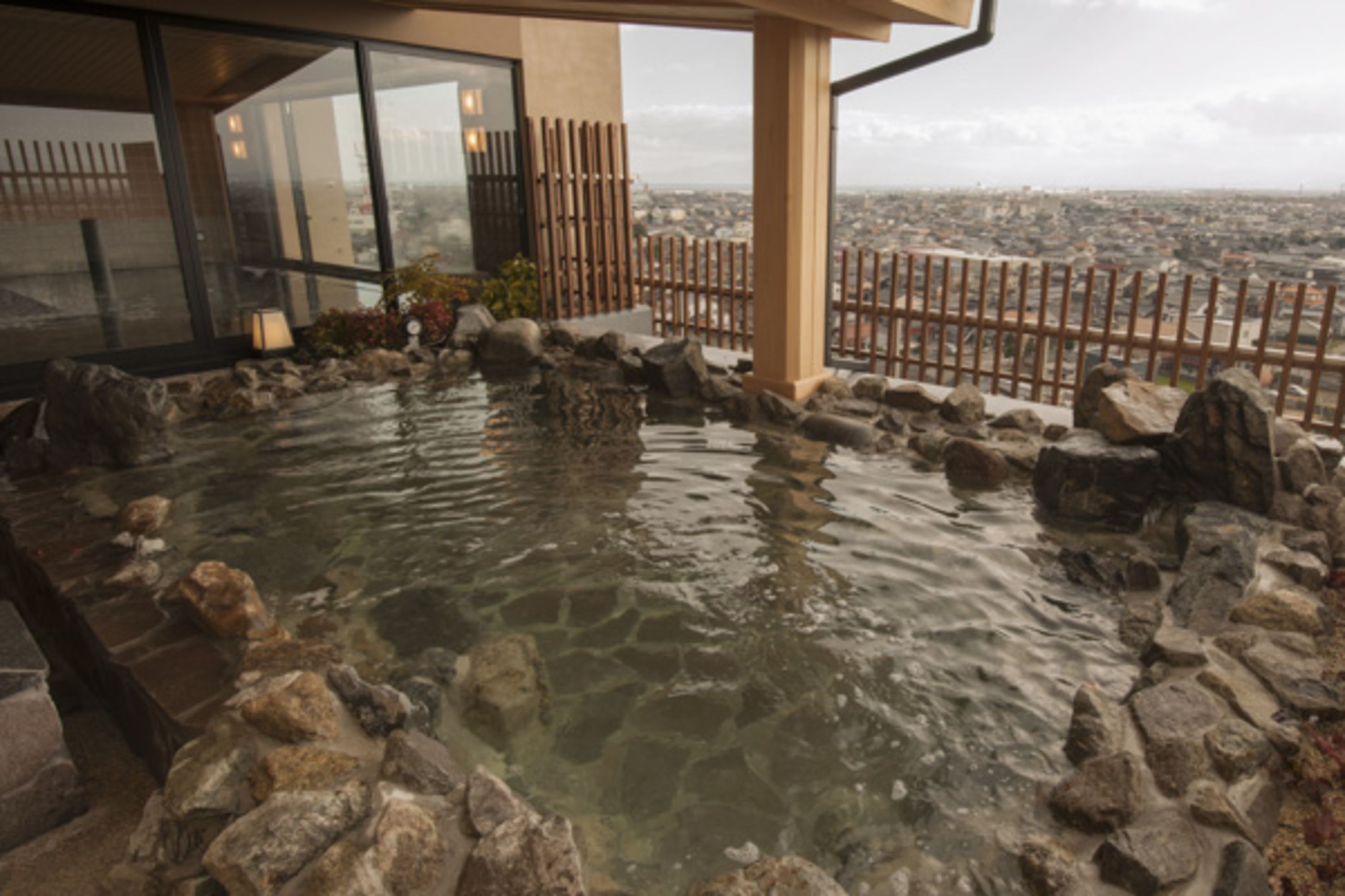 A hot spring area with rocks and a wooden fence.