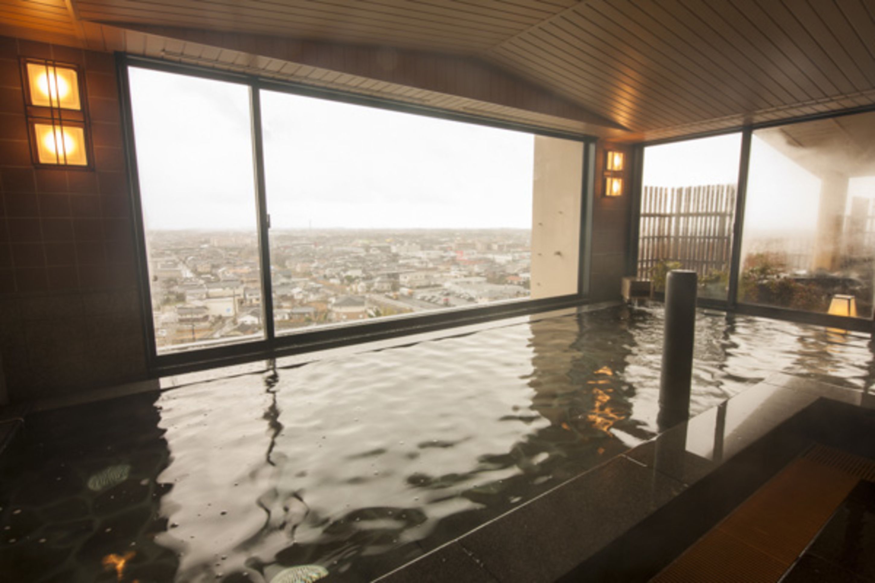 A wet indoor space with large windows overlooking a cityscape.
