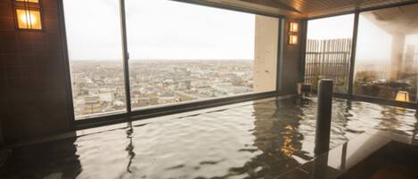 A wet indoor space with large windows overlooking a cityscape.