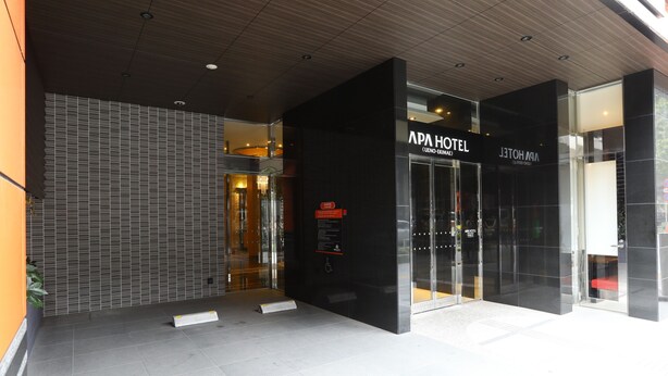 The entrance of APA Hotel with a modern design, featuring a glass facade and a black exterior wall. - APA Hotel Ueno Ekikita (Tokyo)