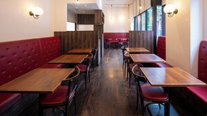 A restaurant interior with booths and tables, wooden flooring, and pendant lighting. - APA Hotel Ueno Ekikita (Tokyo)