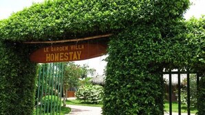 Una entrada con reja y un cartel que dice "Le Garden Villa Homestay".