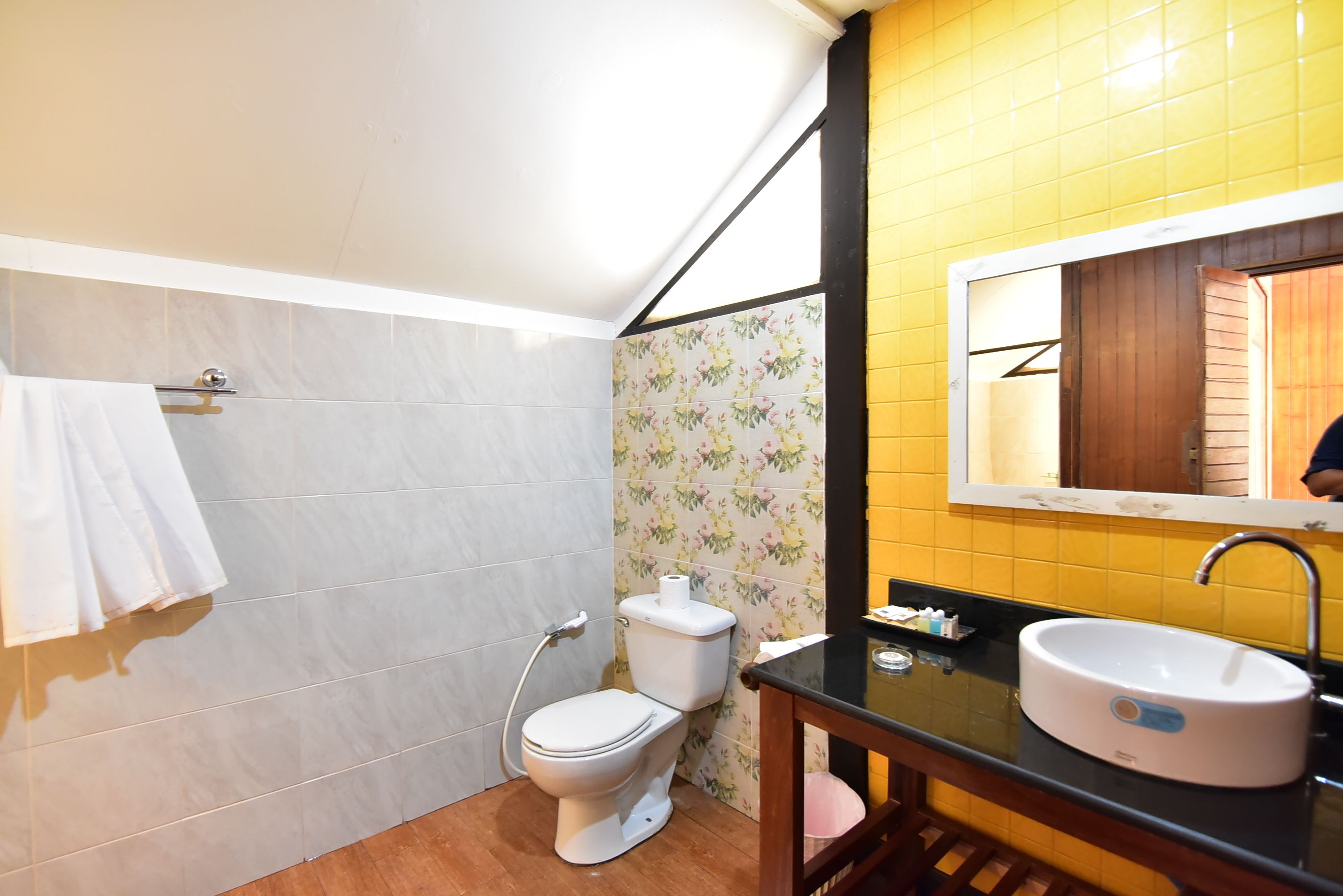A bathroom with a toilet, sink, and mirror.