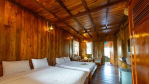 Een houten kamer met twee bedden, een tafeltje en een bank.