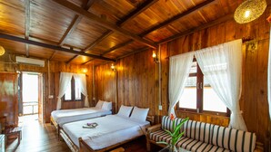 Een houten chalet met twee bedden, een bank en een glazen tafel met een vaas.