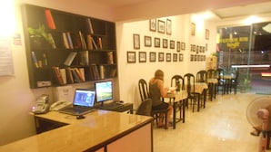A reception area with a counter, computers, and a seating area with chairs and tables.