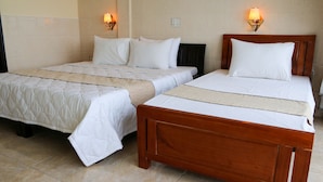 Two single beds with wooden frames and white bedding, each with a wall-mounted light fixture.