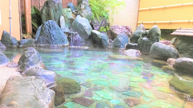A clear pool with large rocks and a bamboo fence in the background. - Onsen Hostel K's House Hakone (Hakone)