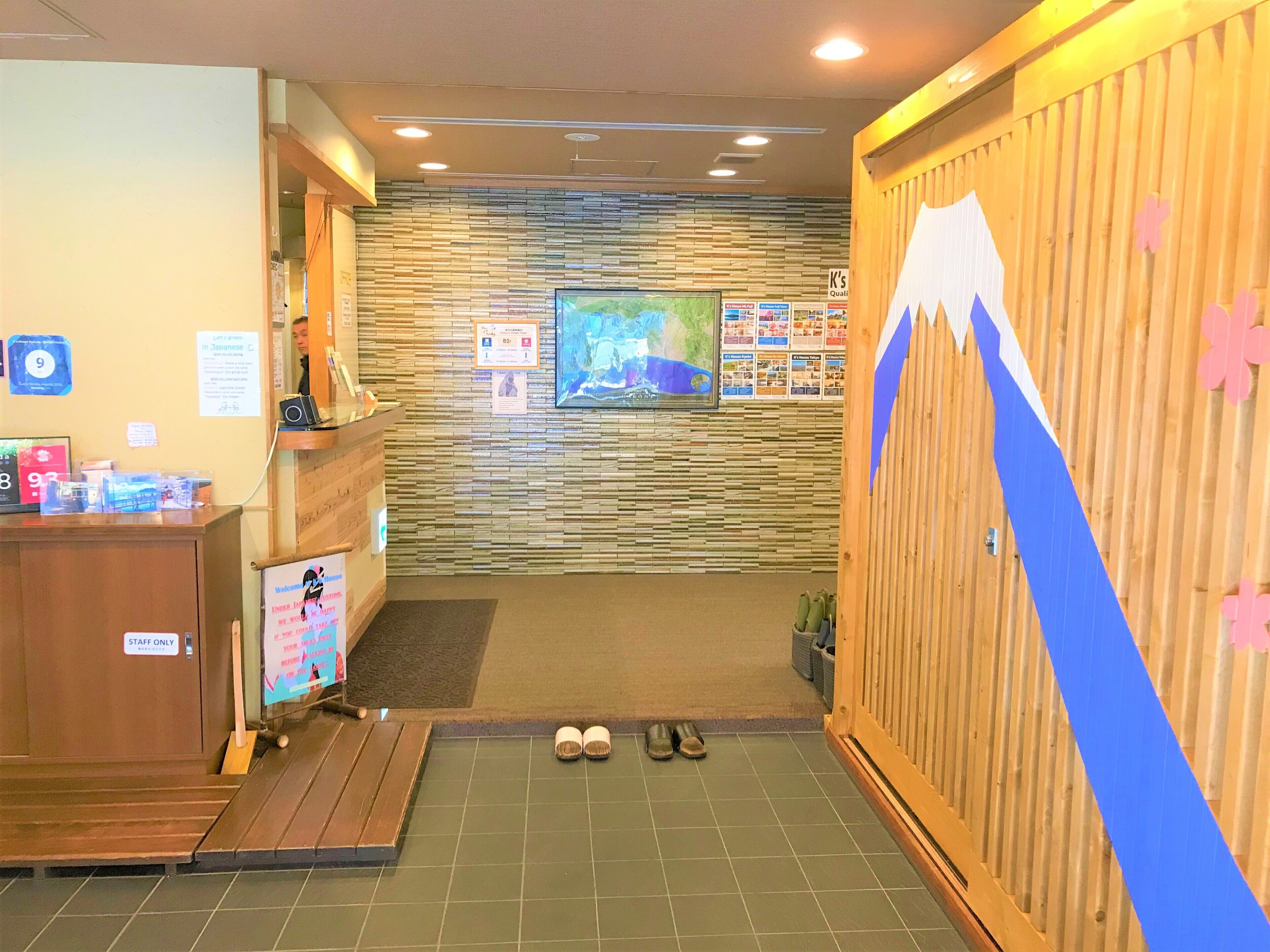 A reception area with a wooden desk, a map on the wall, and a pair of shoes on the floor.