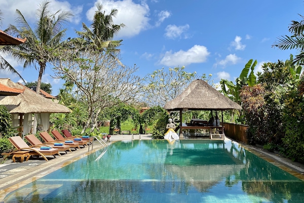 Una piscina al aire libre, tumbonas