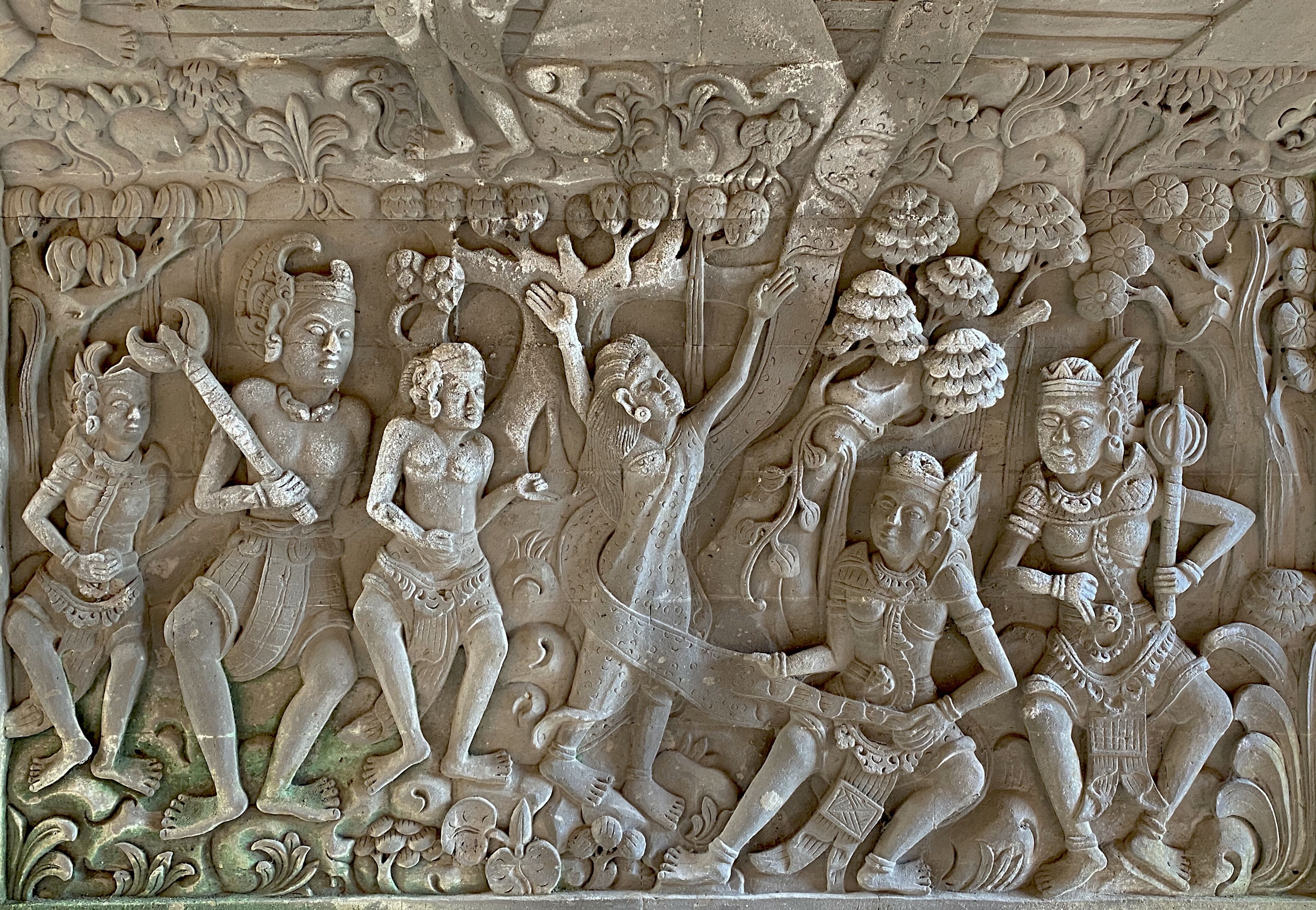 Une sculpture détaillée dans la pierre, représentant des figures et des motifs floraux.