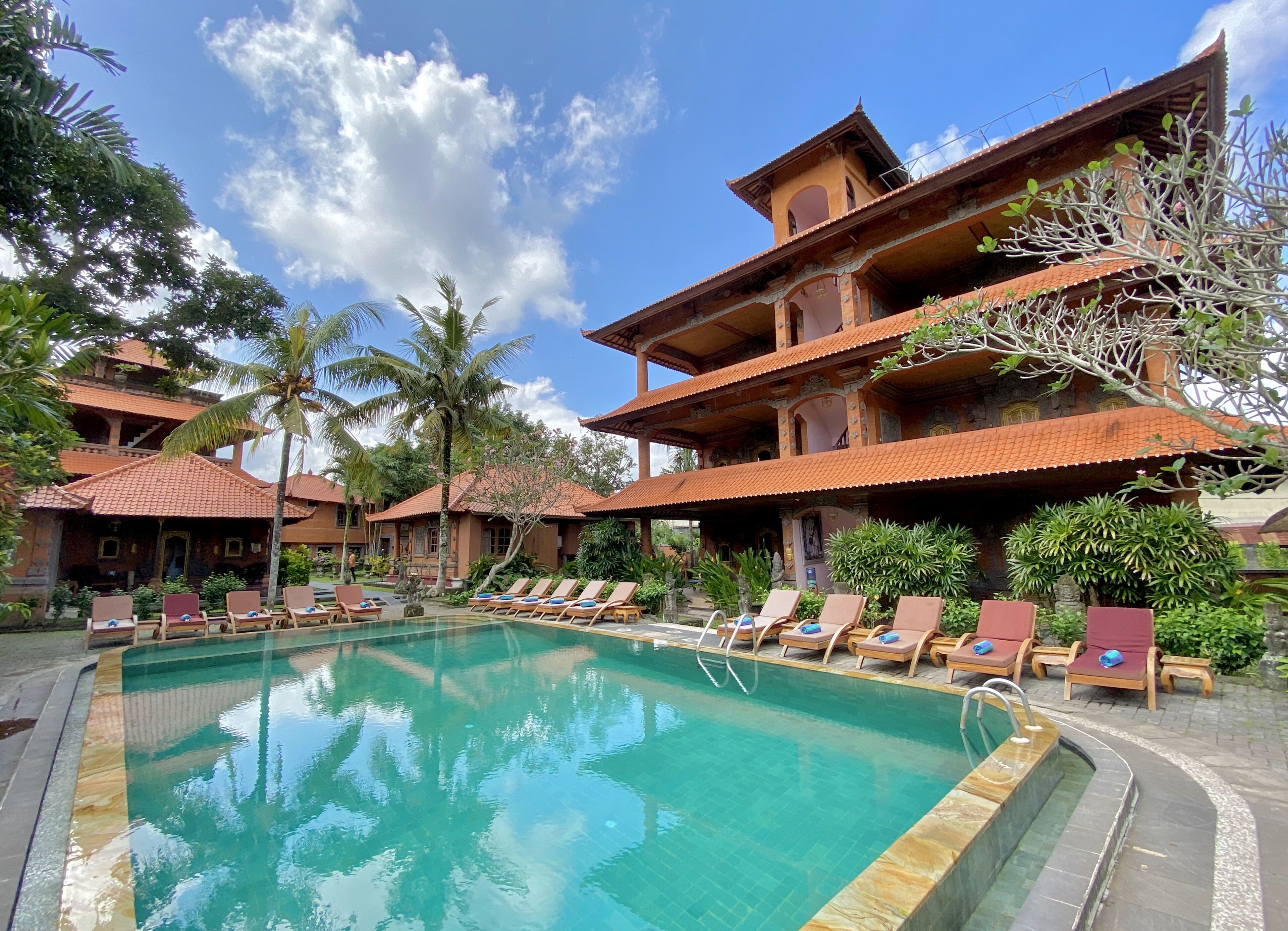 Una piscina al aire libre, sillones reclinables de piscina