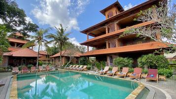 Una piscina al aire libre, sillones reclinables de piscina