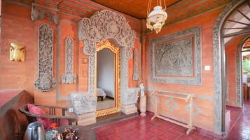 Una habitación con decoración ornamentada, un espejo grande y una mesa con vajilla para té.