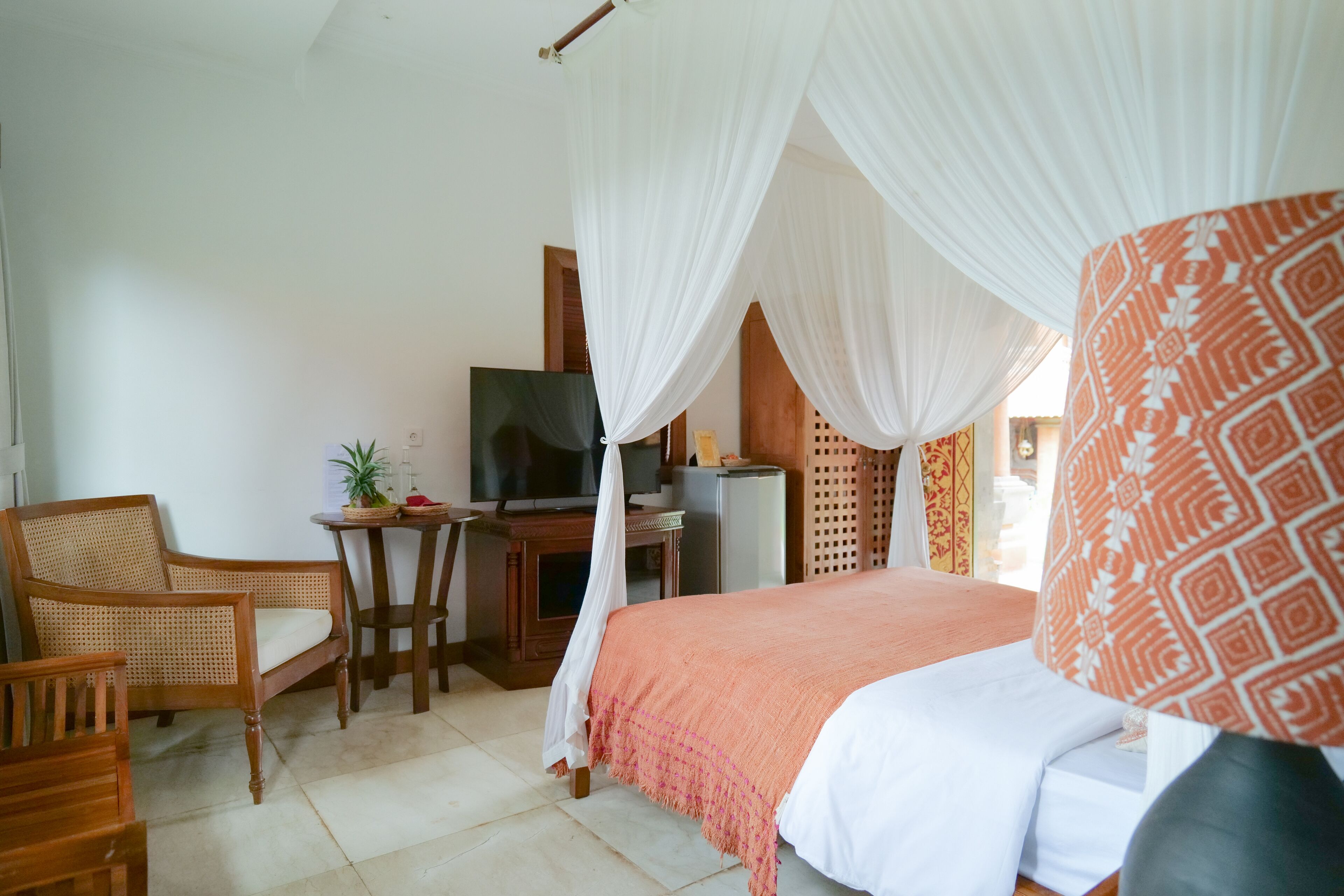 Un dormitorio con cama, televisor, escritorio y silla.