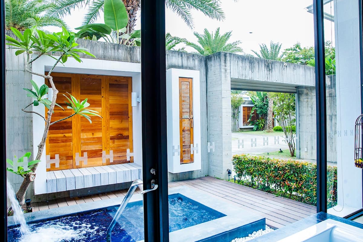 A spa area with wooden cabins, a hot tub, and a small pool.