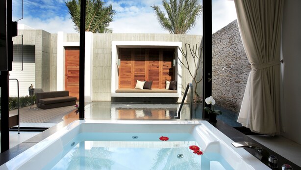 A modern spa area with a hot tub, wooden seating, and a view of the outdoors. - H Villa (Tainan)