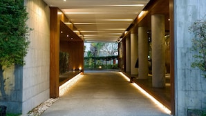 A corridor with concrete walls, wooden beams, and a tiled floor. - H Villa (Tainan)