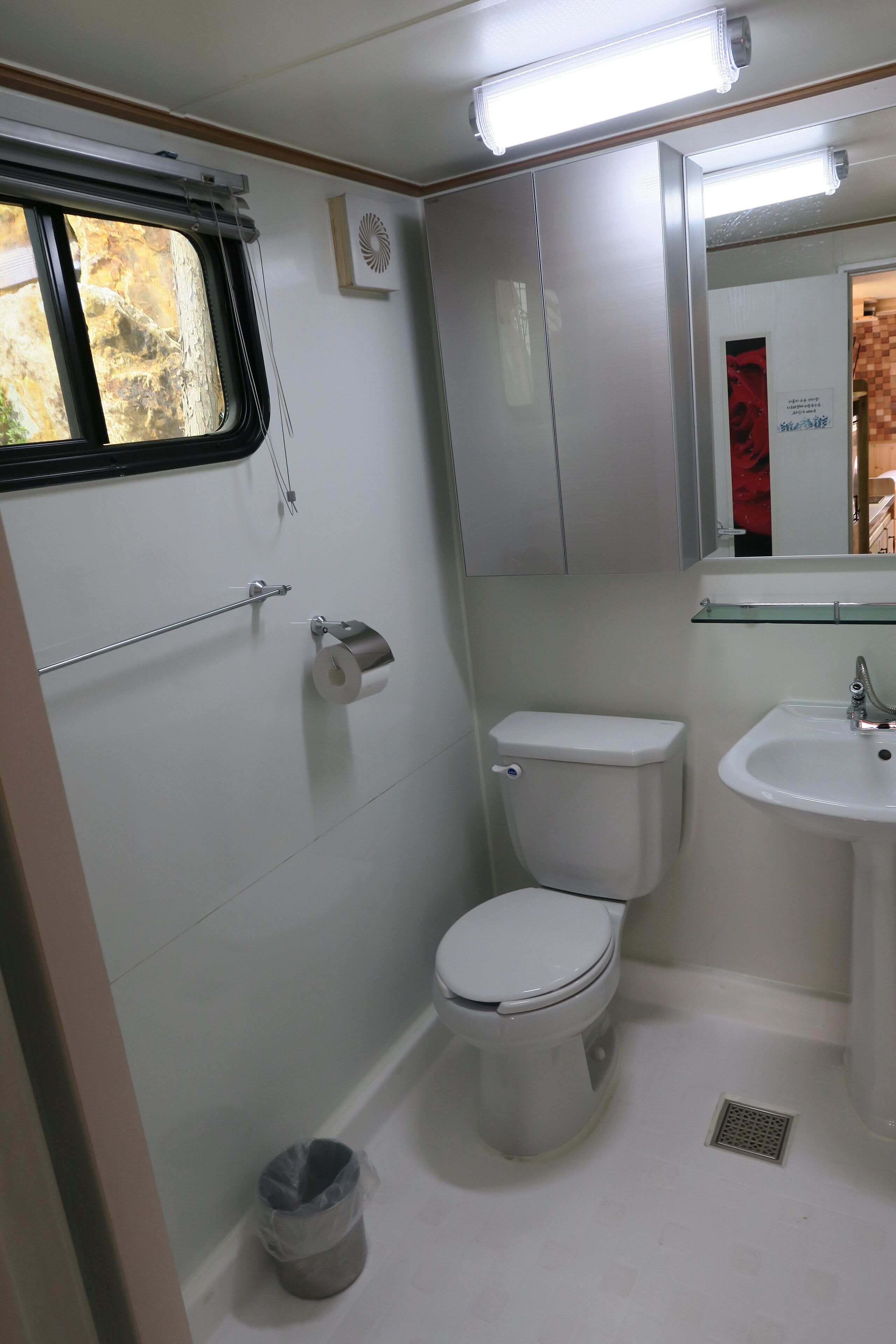 A small, clean bathroom with a toilet, sink, and window.