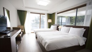 Habitación de hotel con cama, escritorio, computadora, silla y televisión.