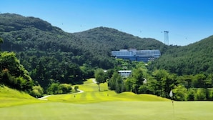 Un campo de golf con un edificio al fondo.