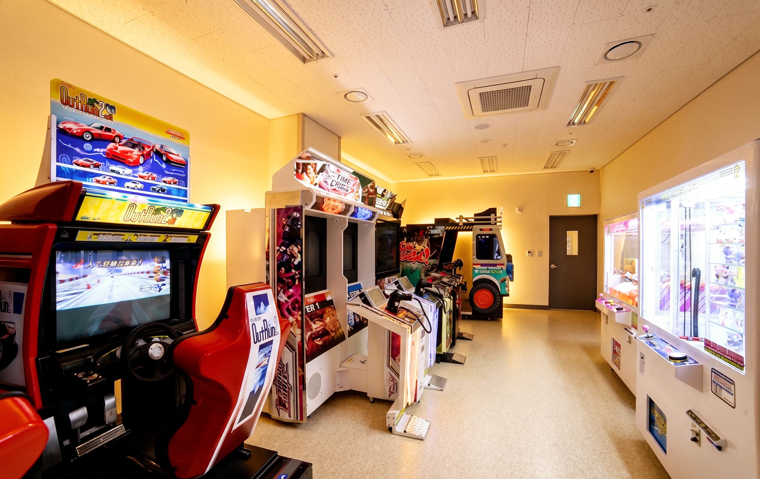 Una hilera de máquinas recreativas en un pasillo con una puerta al final.