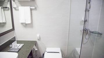 Une salle de bain équipée de toilettes, d’un lavabo et d’une douche.