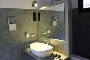 A modern bathroom with a large oval sink, a mirror, and a towel rack. - The Country House (Galle)