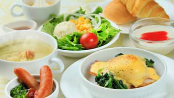 A table with various dishes including soup, salad, and a plate with eggs and greens.