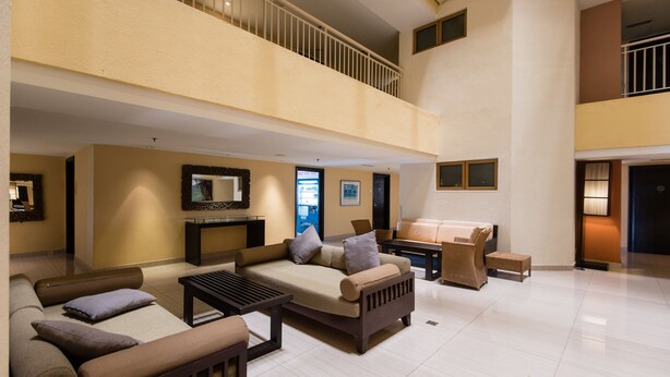 A spacious living area with a high ceiling, a balcony, and a flat-screen TV mounted on the wall. - W Studio Resort Suites at Pyramid Tower (Petaling Jaya)