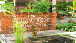 Une enseigne indiquant l’entrée du complexe Eng Rilong Resort, avec une fontaine ou un autre élément aquatique en façade.