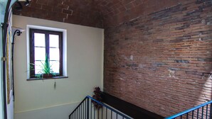 A staircase with a brick wall and a window with plants. - Villa Maria (Vicopisano)
