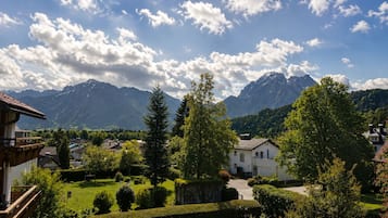 A residential area with houses, a well-maintained lawn, and mountains in the background.