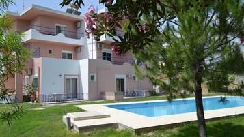 Una piscina al aire libre, sombrillas, tumbonas