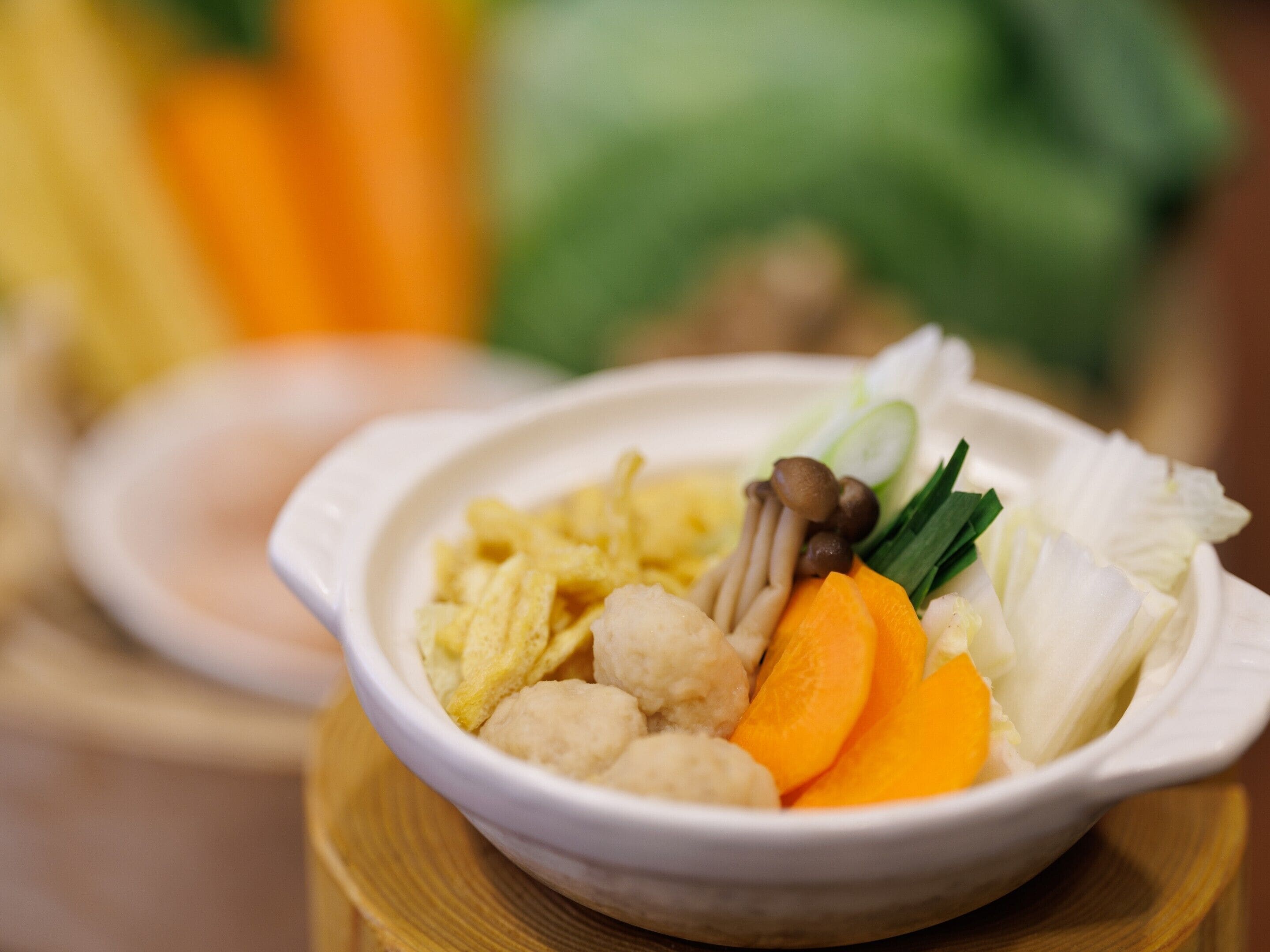 Un tazón con diversos alimentos, incluyendo verduras y hongos.