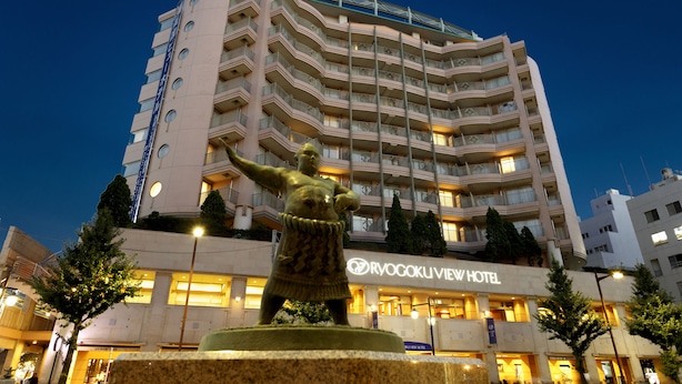 A hotel with a prominent statue in front, multiple balconies, and a clear view of the hotel's name. - Ryogoku View Hotel (Tokyo)