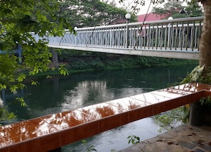 A bridge over a calm river with a tiled walkway.