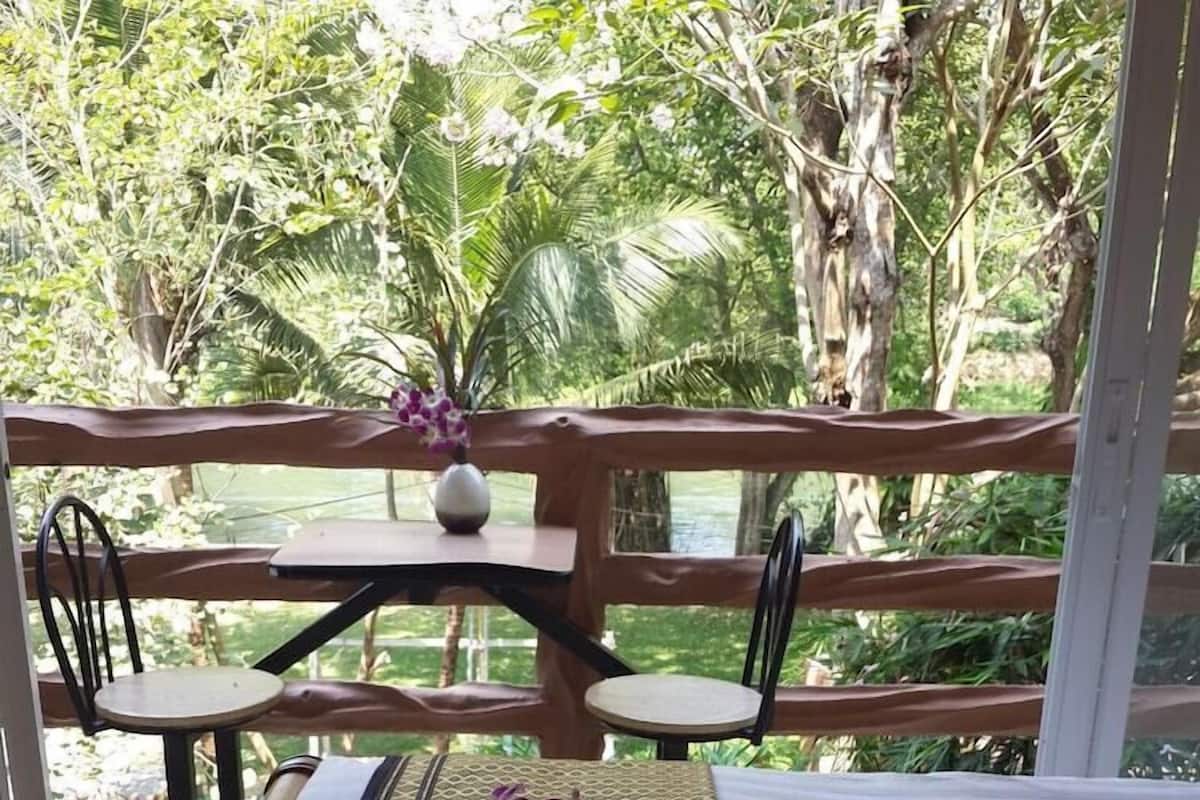 Una habitación con cama, dos toallas con estampado floral, una mesa y sillas.
