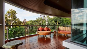A balcony with a wooden floor, two cushioned seating areas, and a glass railing. - NB Villa Vimana (Koh Samui)